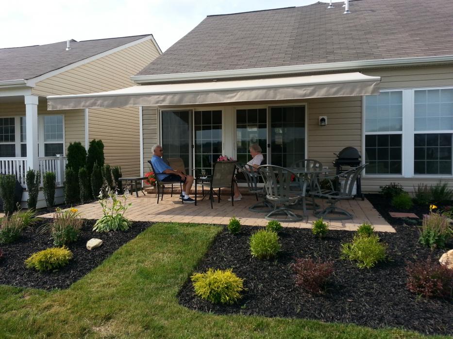 two people sitting at a patio under a retractable awning