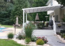 White awning with pergola next to a garden