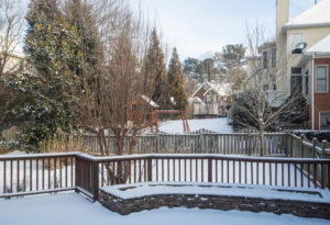 Snow on decks and fences in backyards of houses